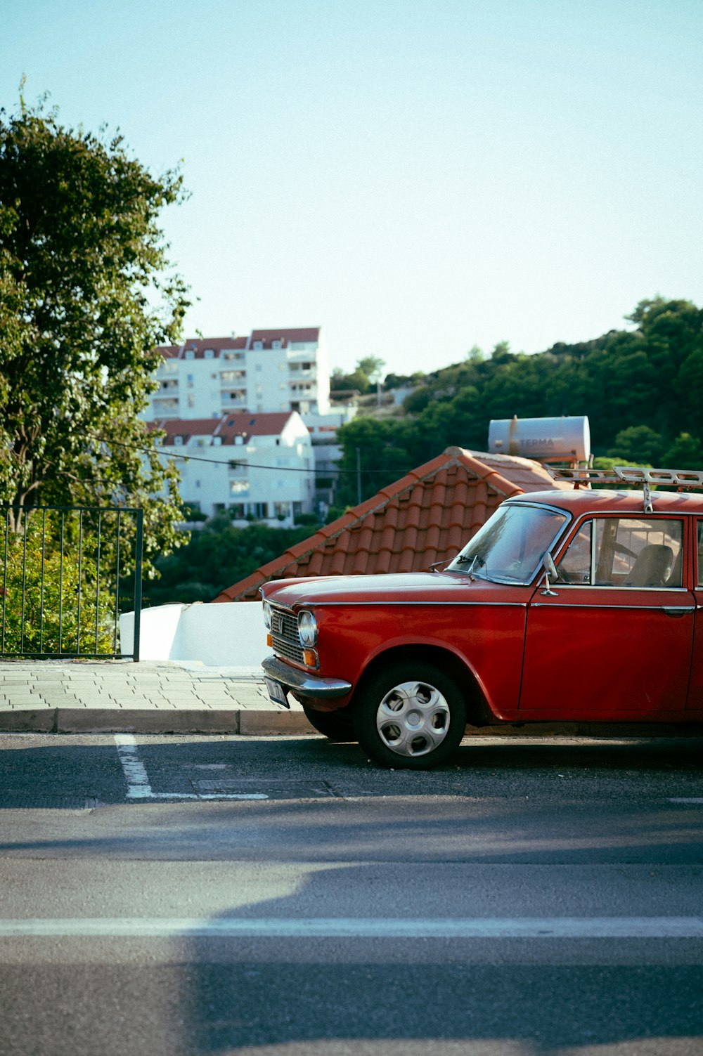 Ein rotes Auto, das am Straßenrand geparkt ist