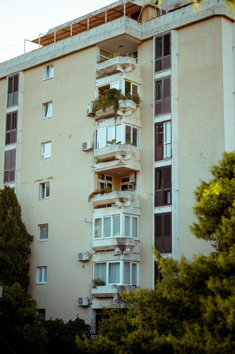 a tall building with balconies and plants on the balconies