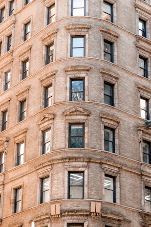 A row of window sills and heads installed on a charming brick building, highlighting their classic design.