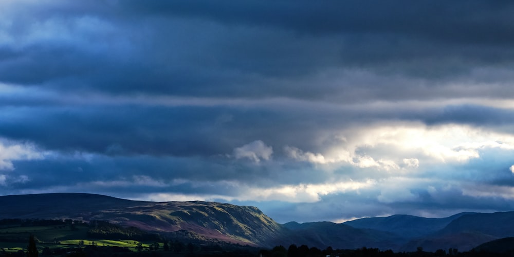 a view of a mountain range under a cloudy sky