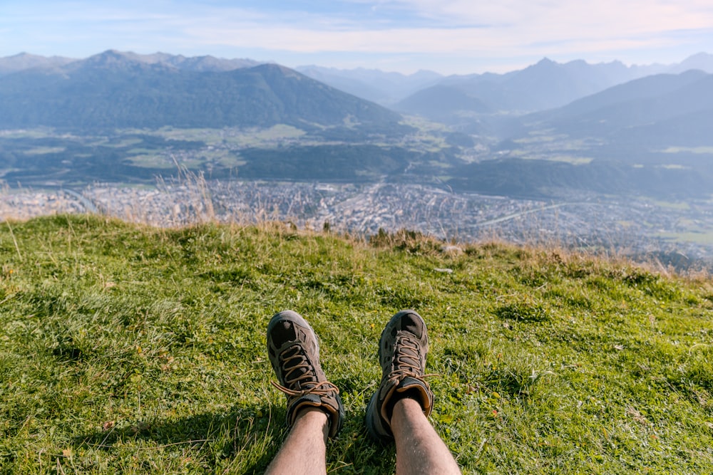 a person with their feet up on a grassy hill