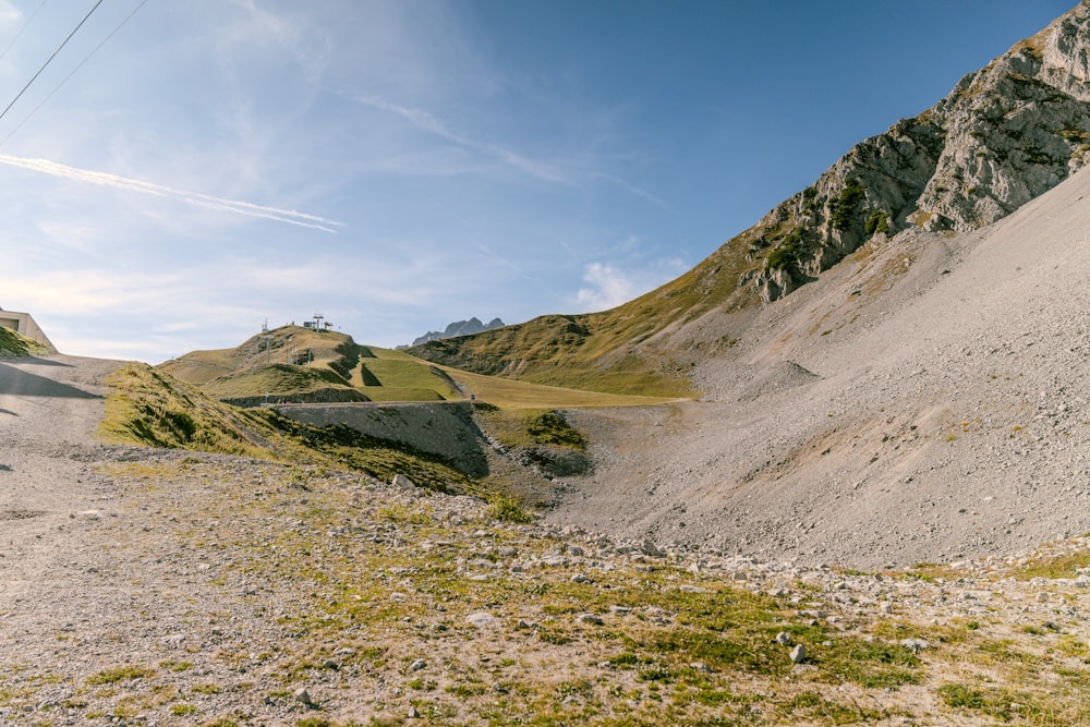 a dirt hill with grass and rocks on it