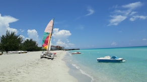 a beach with a boat and a sailboat in the water