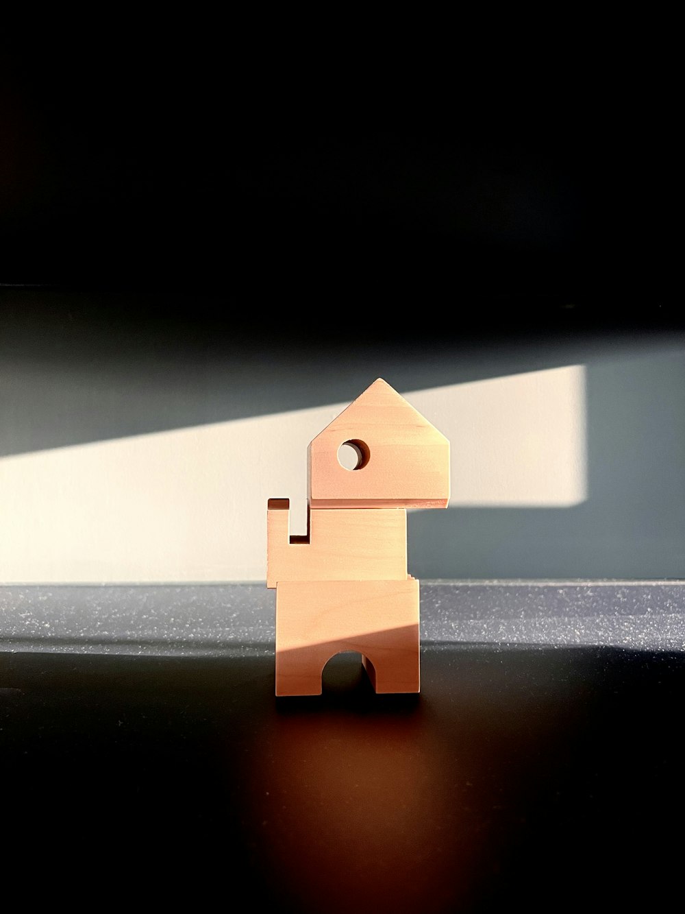 a small wooden figure sitting on top of a table