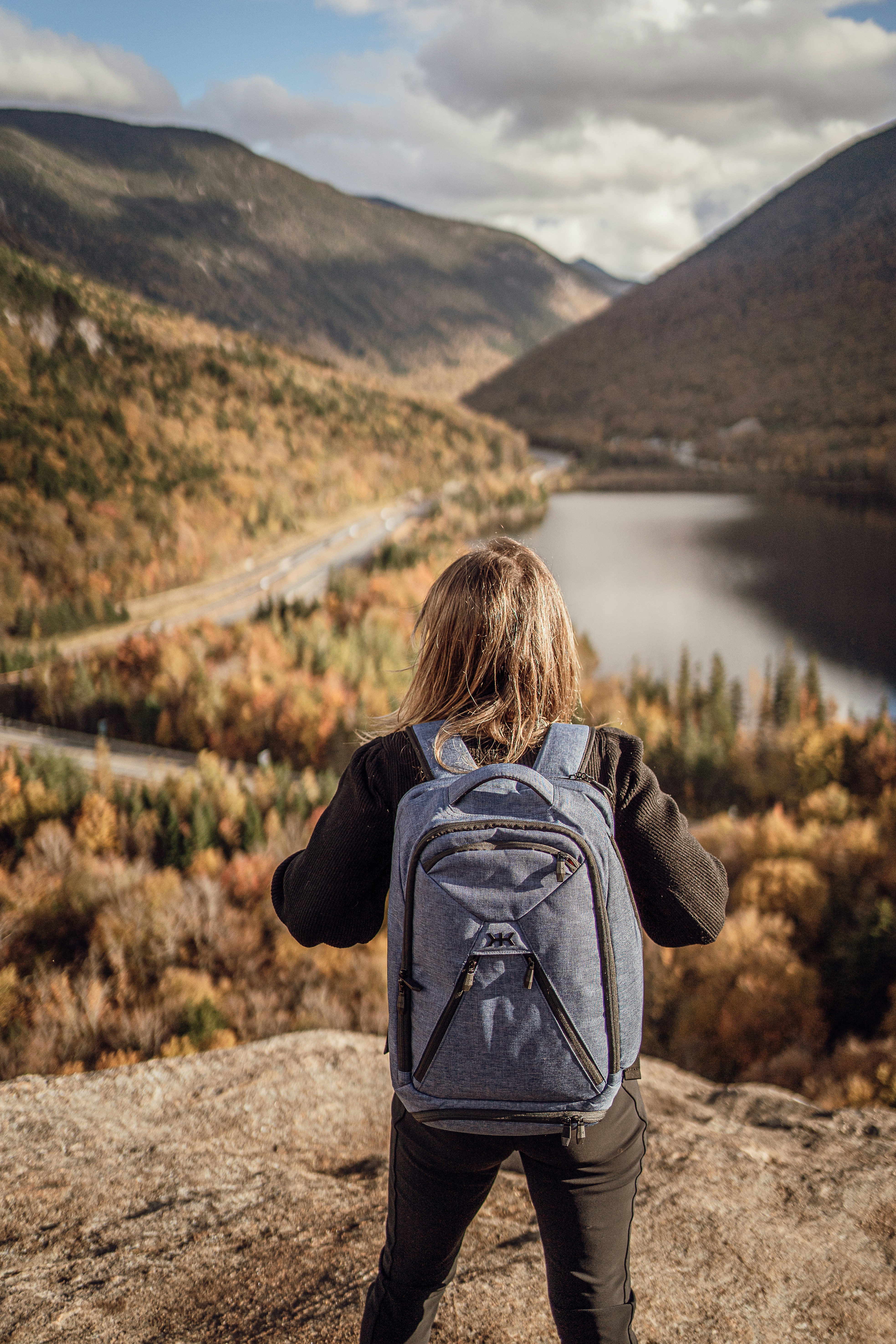 a person with a backpack standing on a rock