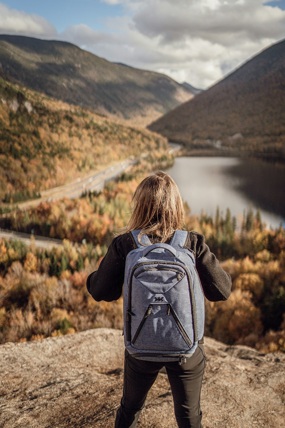 a person with a backpack standing on a rock