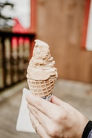 a person holding an ice cream cone in their hand