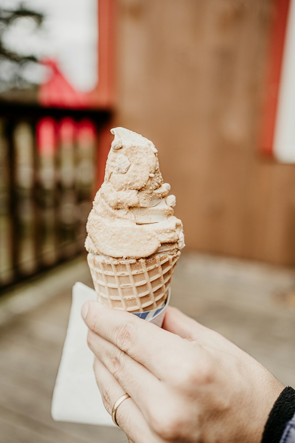 a person holding an ice cream cone in their hand