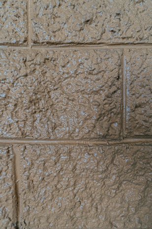 Close-up of a wall being textured with serracor atacadão's signature paint product in a warm, inviting room.