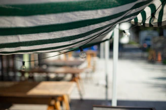 Close-up of colorful fabric awnings stretched over a cozy outdoor patio.