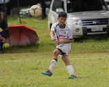 A focused u13 player diving to save a ball during a heated match.