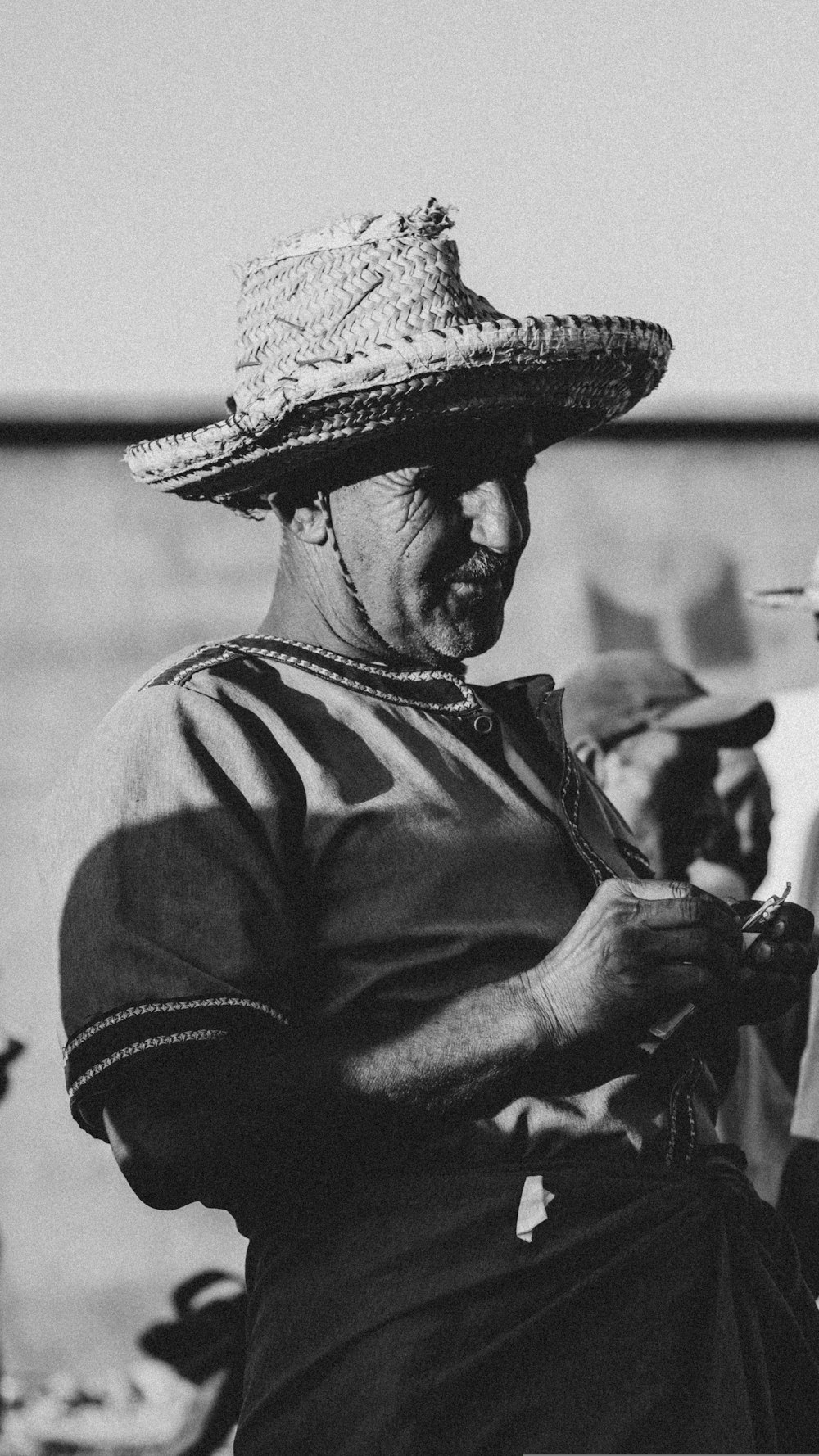 a black and white photo of a woman wearing a straw hat