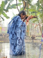 An elder guiding the younger generation through the steps of the tharpanam ceremony by the riverbank.