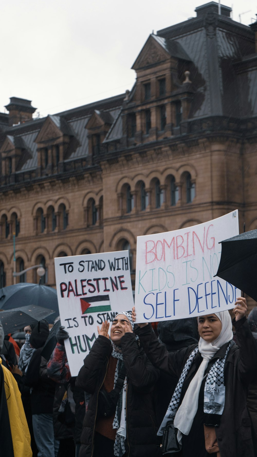 a group of people holding signs in front of a building