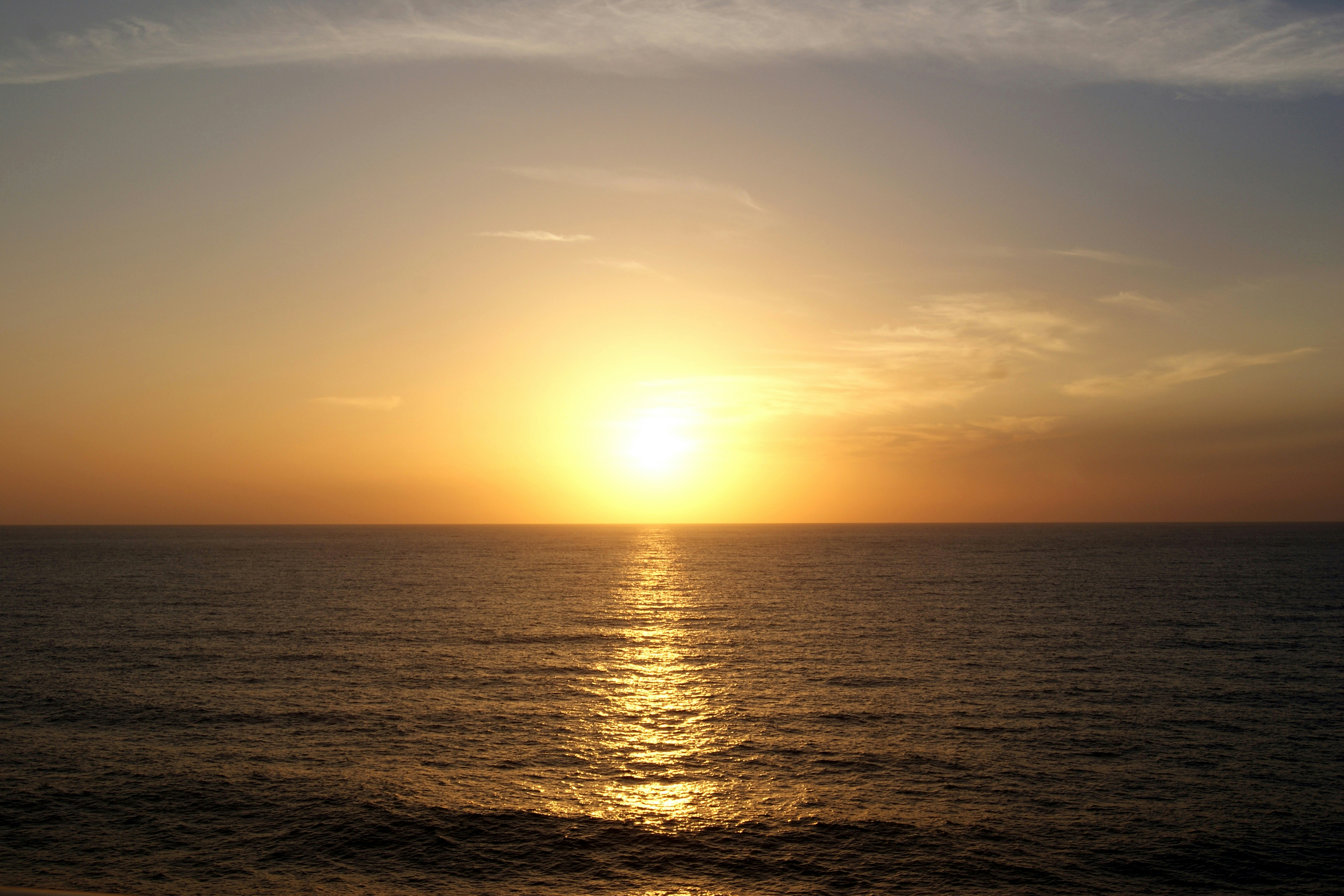 the sun is setting over the ocean on a clear day