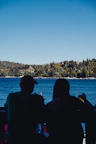 Guests enjoying morning coffee on the balcony with panoramic lake scenery.