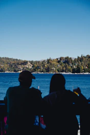 Guests enjoying morning coffee on the balcony with panoramic lake scenery.