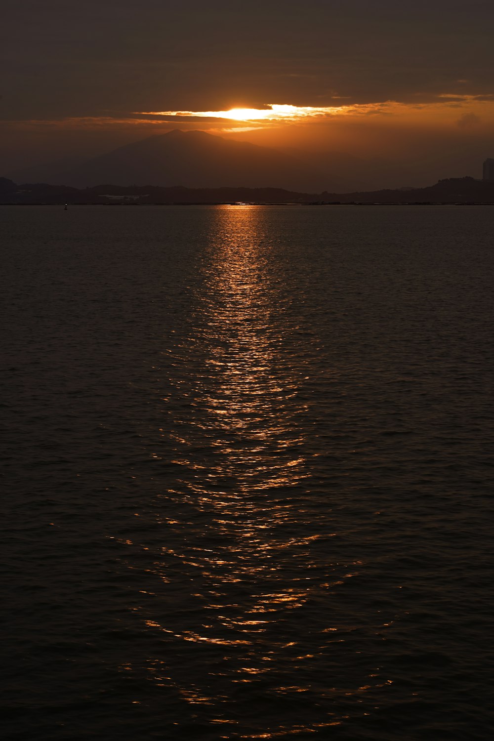 a large body of water with a sunset in the background