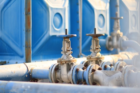 Close-up of industrial pipes and valves in an oil refinery facility.