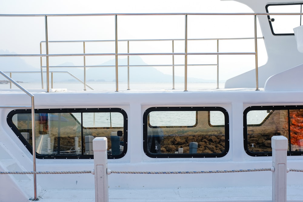 a white boat with three windows and railings
