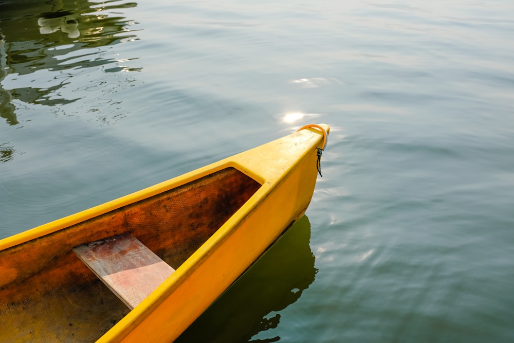 a yellow boat floating on top of a body of water