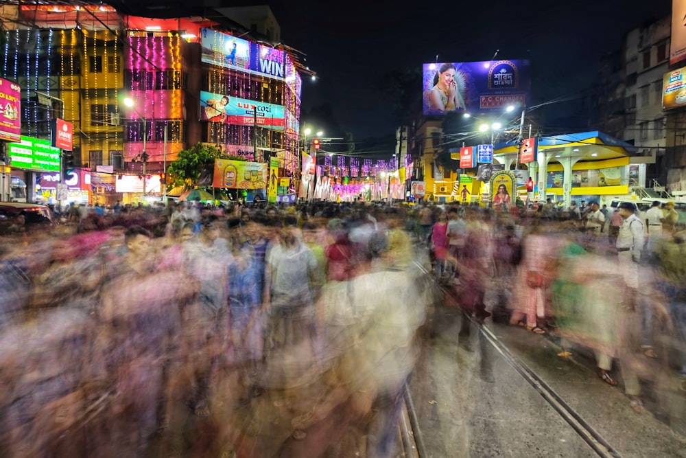 a crowd of people walking down a street at night