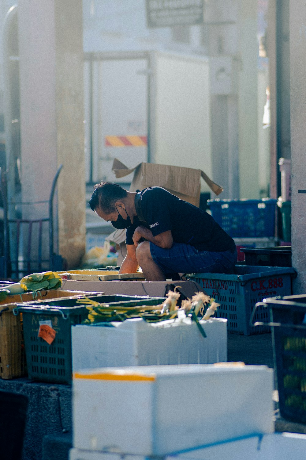 a man sitting on the ground next to boxes of food