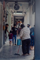 Cleaning crew working efficiently in a bright office corridor.
