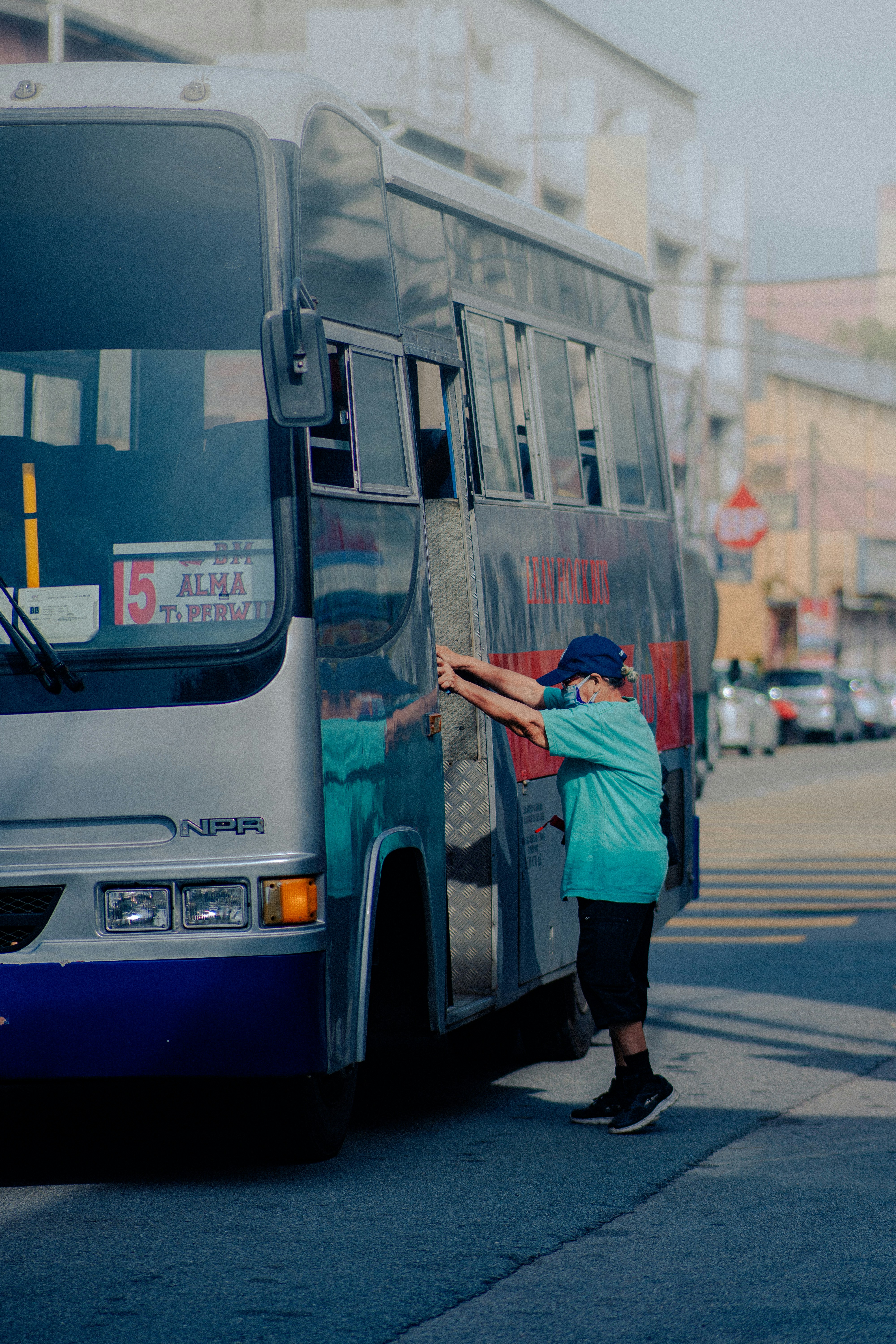 a person standing next to a bus on a city street