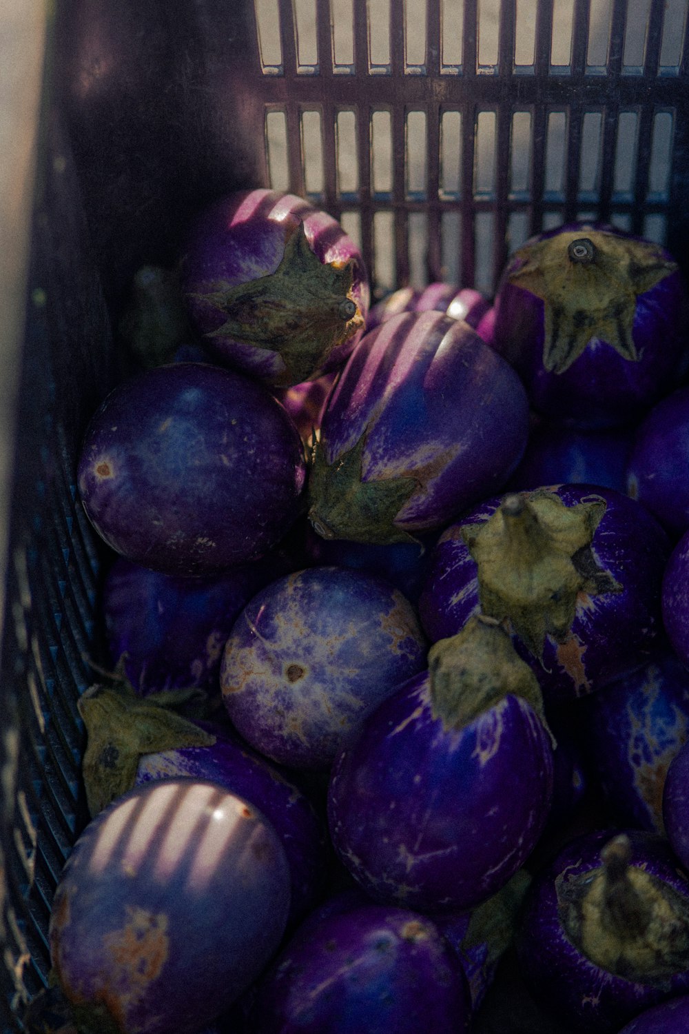 a basket full of purple eggplant sitting on top of a table