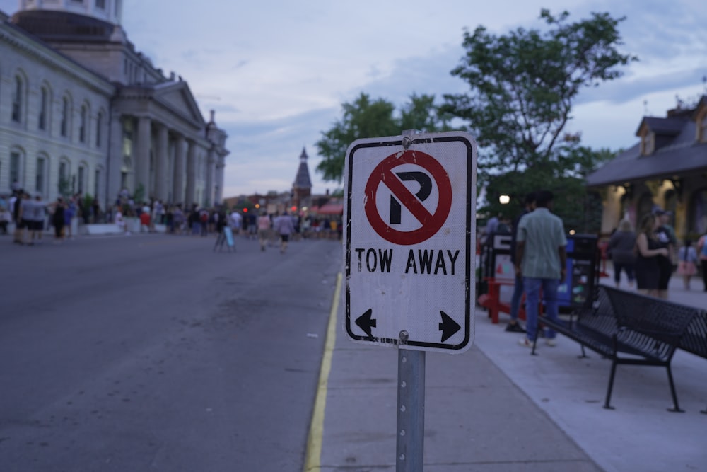 a no parking sign sitting on the side of a road