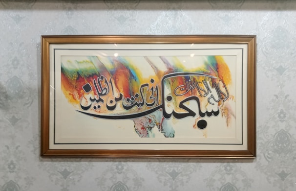 Close-up of a traditional Arab calligraphy artwork displayed in the gallery.