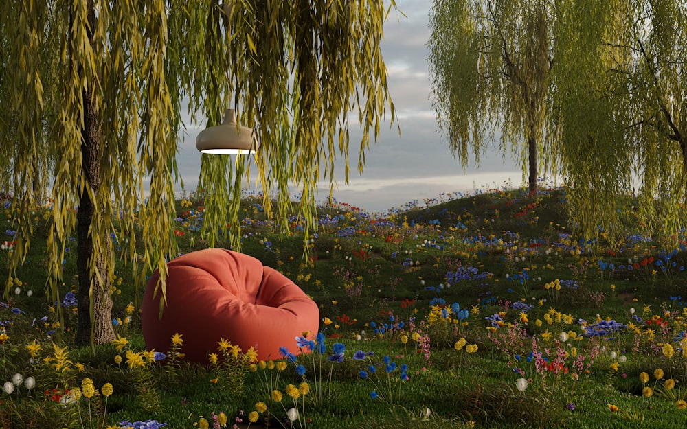 a red bean bag chair sitting in the middle of a field of flowers