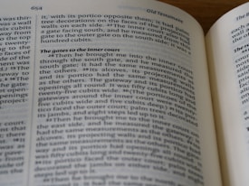 An open book with visible printed text, featuring a biblical reference from the Old Testament. The page number 654 is displayed at the top, and text blocks are separated into paragraphs with headings in a larger font.