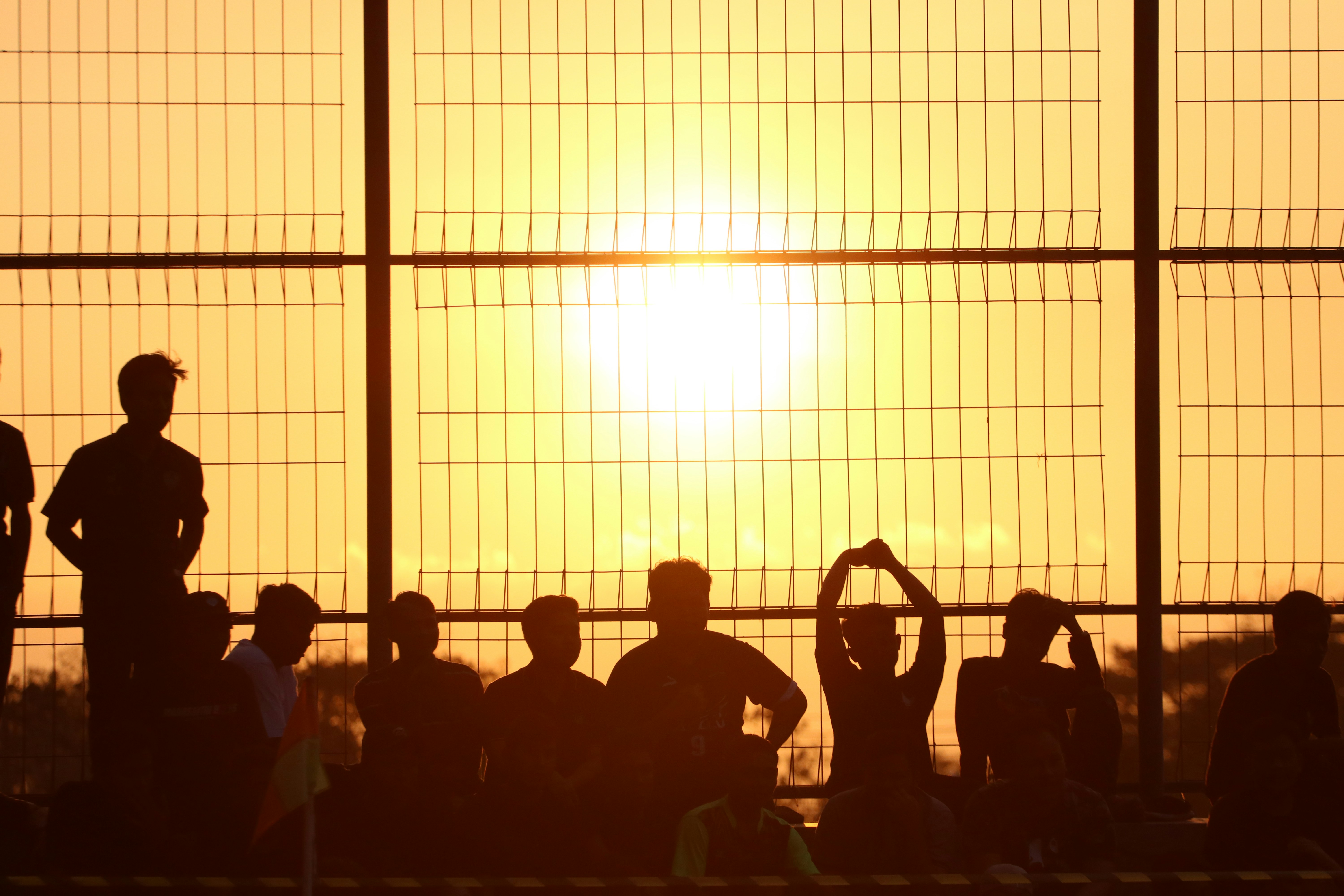 a group of people standing next to each other near a fence