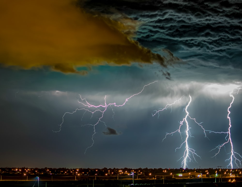 a lightning storm is seen over a city at night