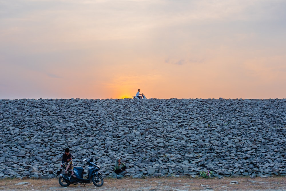 a couple of people riding motorcycles down a dirt road