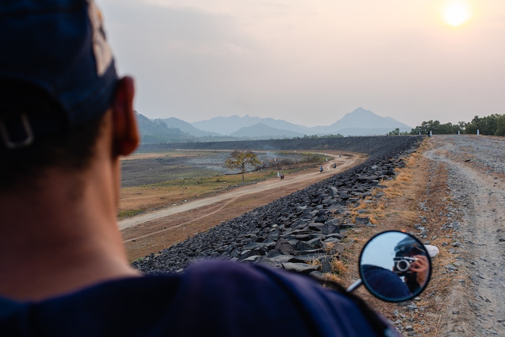 a man taking a picture of himself in the side mirror of a car