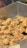 A close-up view of a pile of crispy, fried food items that appear to be pieces of fried chicken or similar battered food. The texture looks crunchy and golden with shredded bits scattered around them, indicating they have been freshly fried.