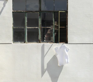 Dark minimalist urban t-shirt hanging on a sleek black hanger with subtle neon highlights
