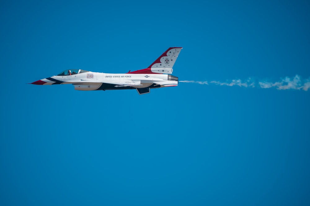 a fighter jet flying through a blue sky