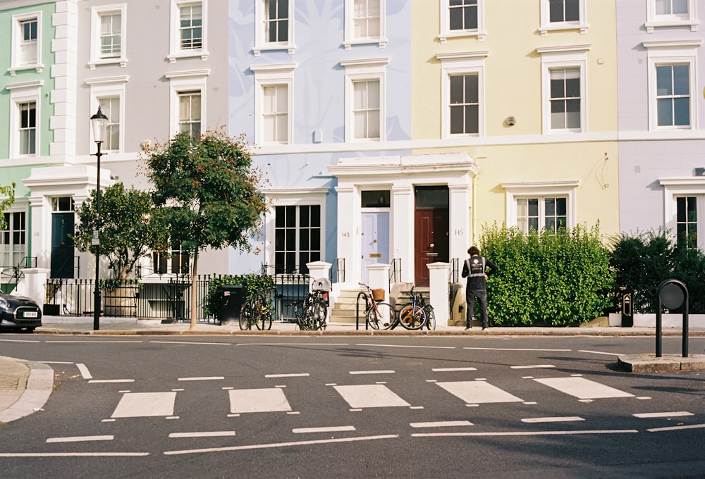 a crosswalk in front of a row of multi - colored buildings