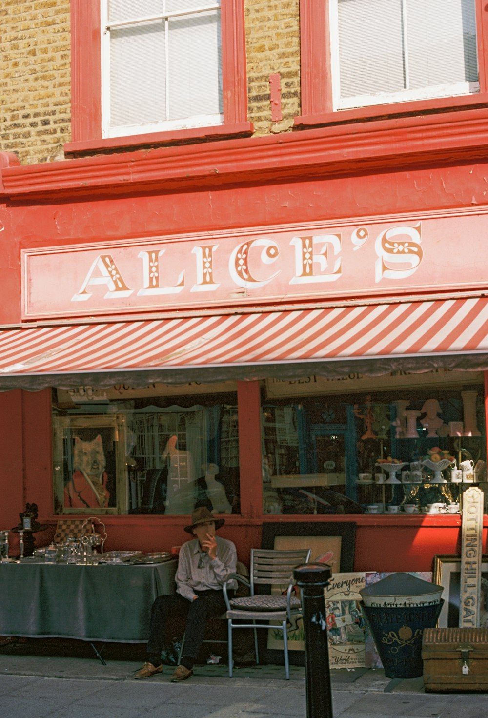 a man sitting on a bench in front of a store