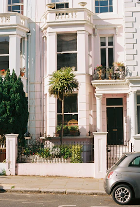 Exterior view of a renovated Victorian house with a freshly painted facade and tidy garden.