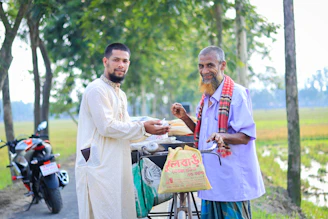 A friendly Velocetrade agent handing over cash to a happy customer with a bike in the background.
