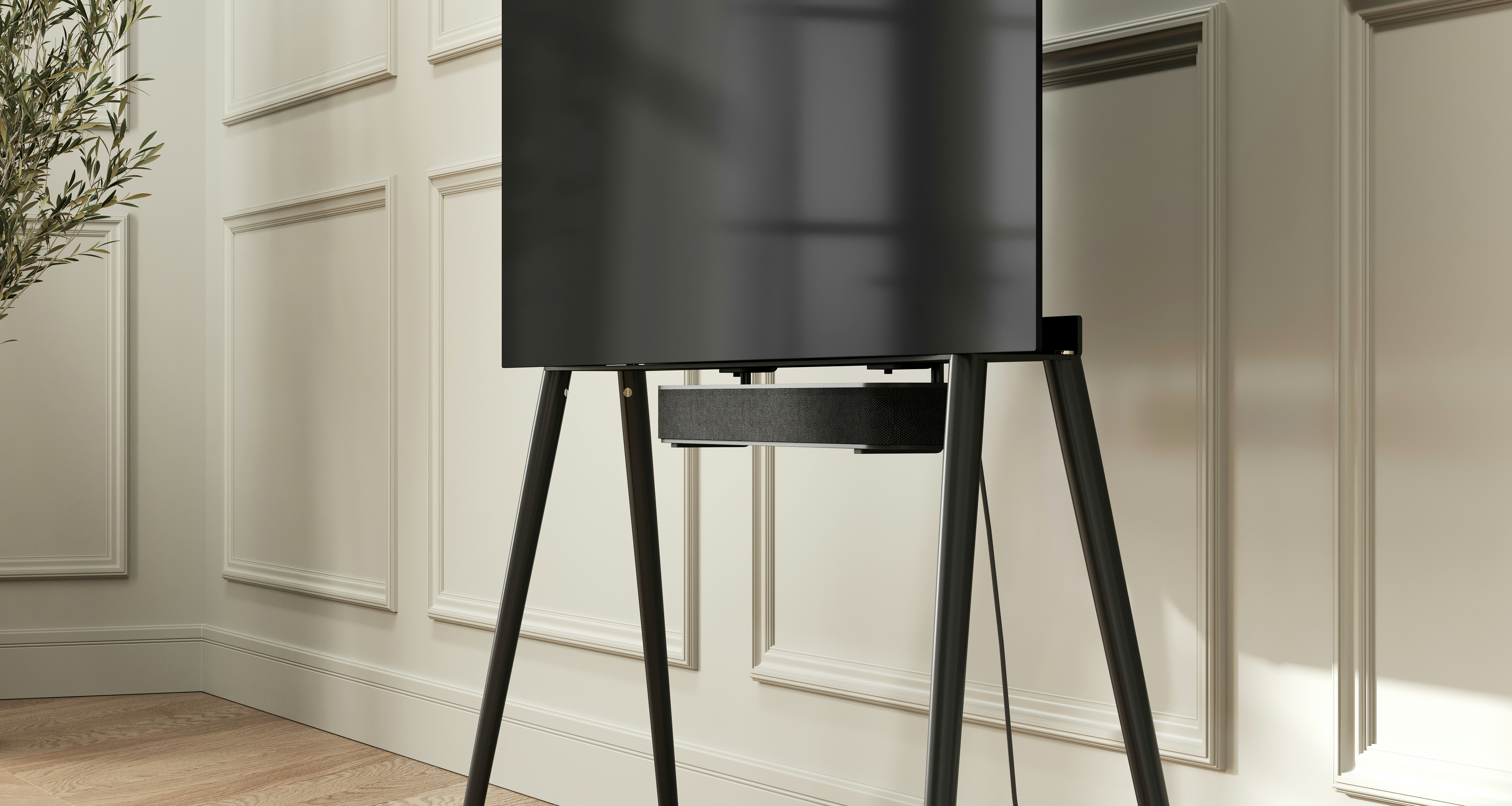 a black speaker stands in front of a white wall