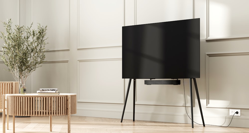 a flat screen tv sitting on top of a wooden stand