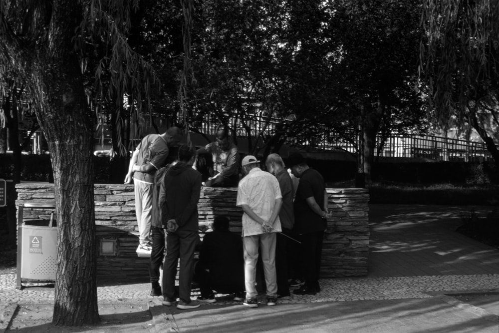 a group of people standing around a stone wall