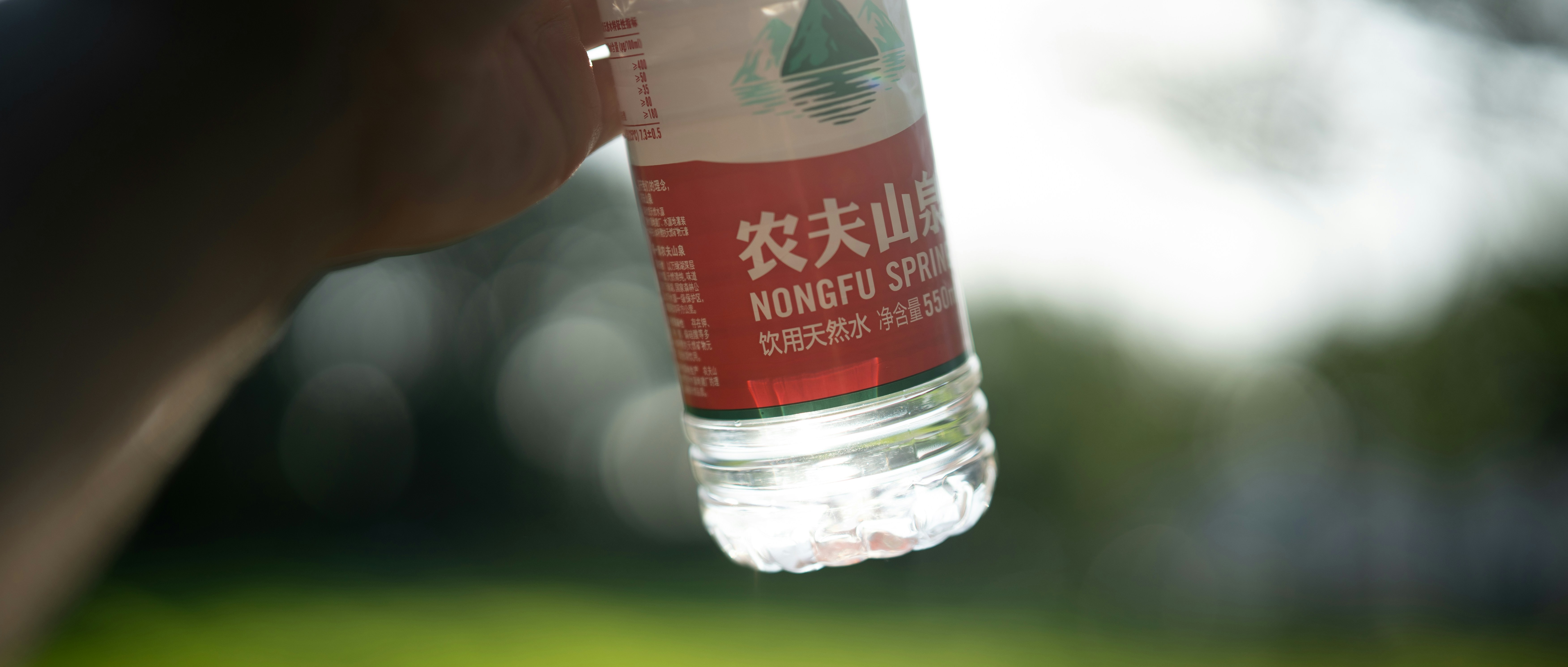 seseorang memegang sebotol air di tangan mereka