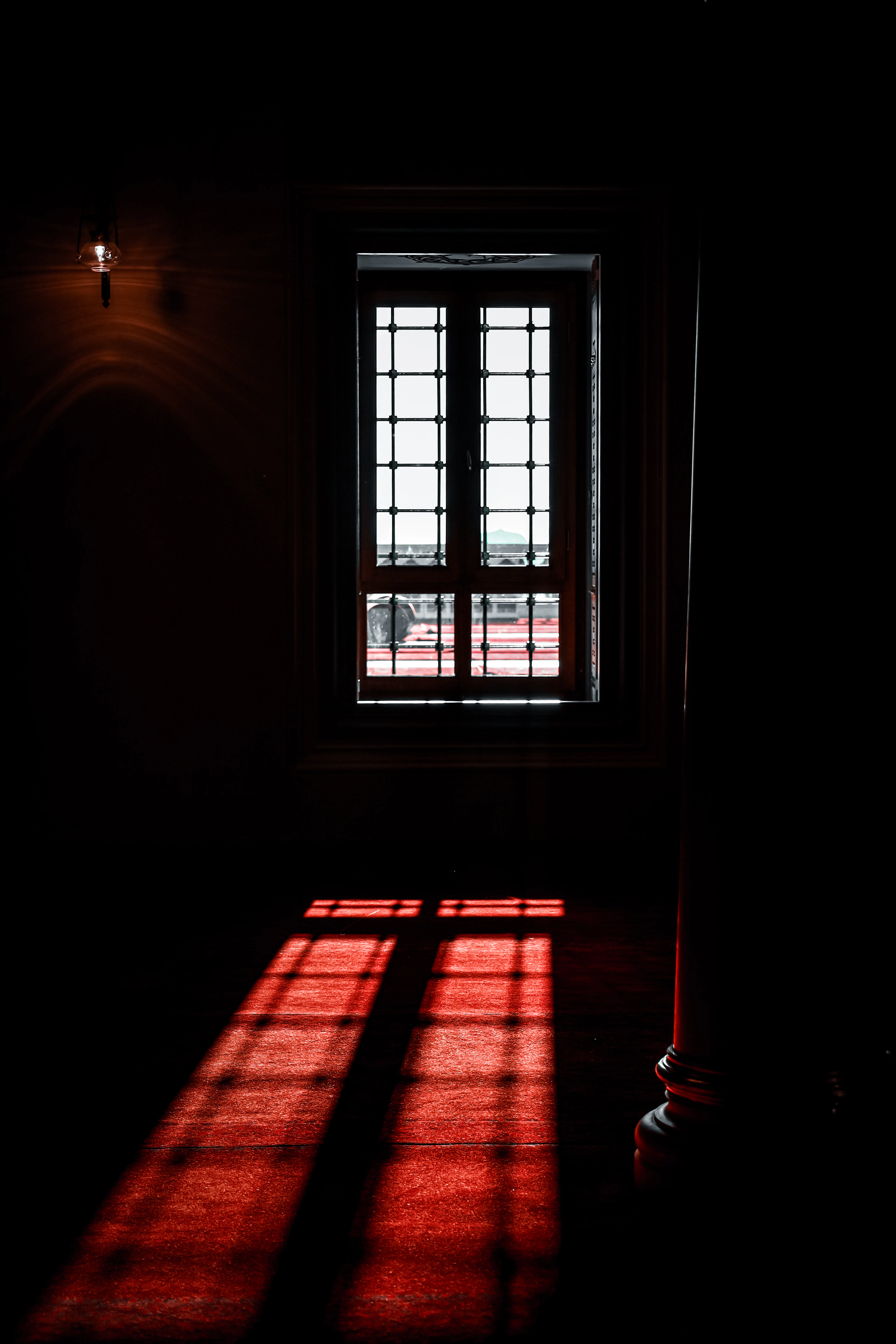 Quarto escuro com luz do sol entrando pela janela